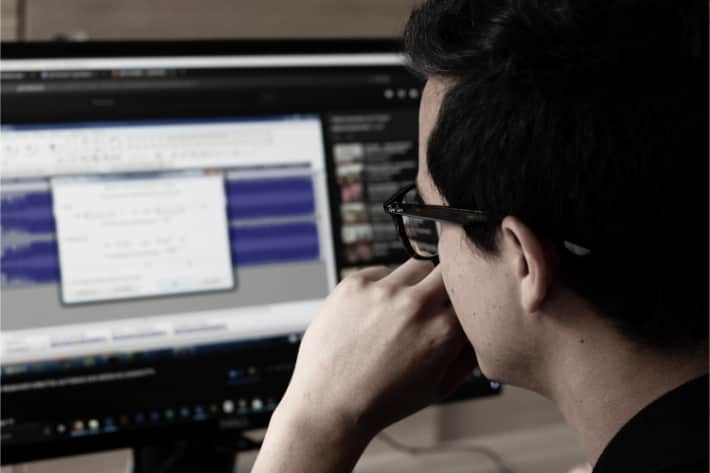 Homme à lunettes regardant l'ordinateur d'un écran sur lequel il y a une fenêtre pop-up